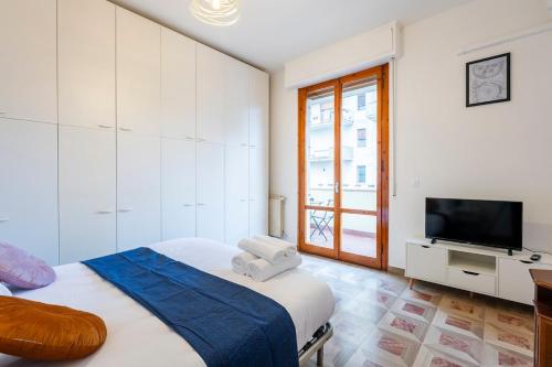 Un dormitorio blanco con una cama y un televisor. en Near Airport 8 Guests - Big Elegant Apartment, en Florencia