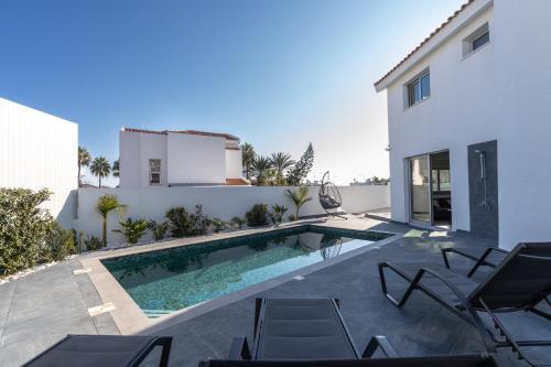 a swimming pool in the backyard of a house at Mediterranean Oasis Protaras in Protaras