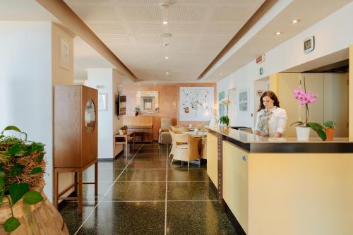 ディアーノ・マリーナにあるHotel Liliana Diano Marinaの部屋の窓口に立つ女