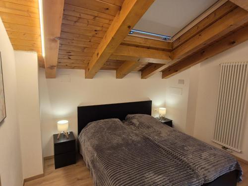 a bedroom with a bed and two night stands at Casa Sasso Bianco in Rocca Pietore