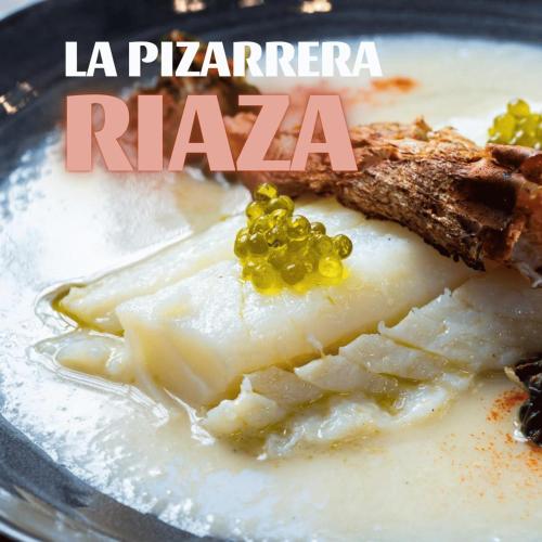 a plate of food with cheese and green grapes at Hotel Rural La Encantada en Riaza in Becerril