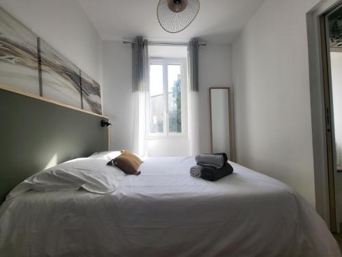 une chambre avec un grand lit blanc avec une fenêtre dans l'établissement Maison Auguste R., à Avignon