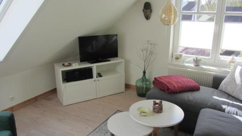 ein Wohnzimmer mit Sofa und Fernseher in der Unterkunft Kuschelkoje 2 Edition in Eckernförde