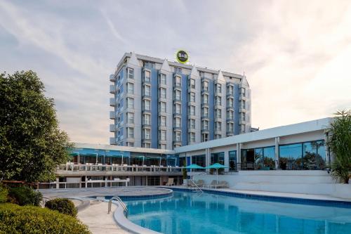 a hotel with a swimming pool in front of a building at B&B Hotel Chioggia Airone in Sottomarina