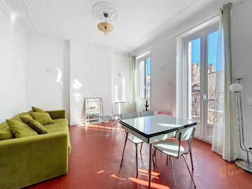 un salon avec un canapé vert et une table dans l'établissement Appartement Central - Balcon & Lumineux - Les Frères de la Loc', à Marseille