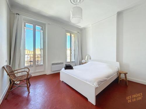 - une chambre blanche avec un lit, une chaise et des fenêtres dans l'établissement Appartement Central - Balcon & Lumineux - Les Frères de la Loc', à Marseille