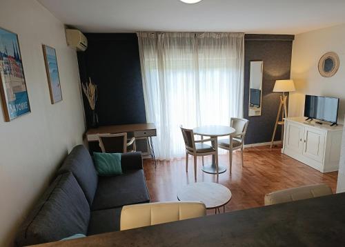 a living room with a couch and a table at Résidence Carouge Appart Hôtel in Brétigny-sur-Orge