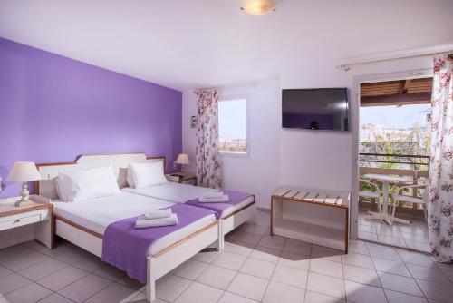 a hotel room with a bed and a balcony at Primavera Beach Hotel Studios & Apartments in Malia