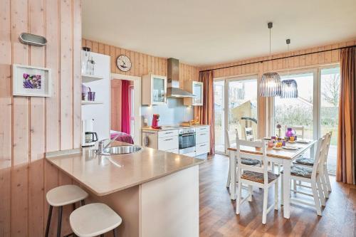 a kitchen with a sink and a table with chairs at Typ F "John Flint" -Kapitänshaus- in Pelzerhaken