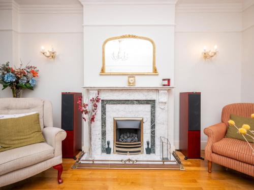 ロンドンにあるSpacious 3bedroom house near Crystal Palace London Pass the Keysのリビングルーム(暖炉、椅子2脚付)