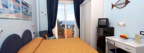 Dormitorio con cama, escritorio y TV en Hotel Solemare, en Albenga