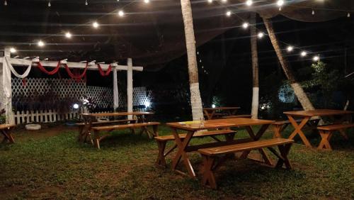 a group of picnic tables under a tent at night at Dom Pedros Haven Resort - Tranquil Retreat by the Sea in Utorda