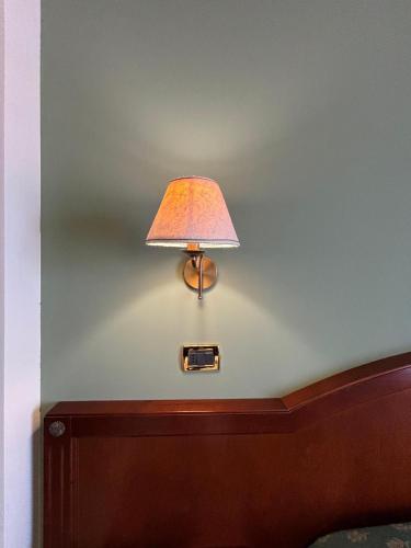 a lamp on a wall next to a bed at Hotel Valle Rossa in San Giovanni Rotondo