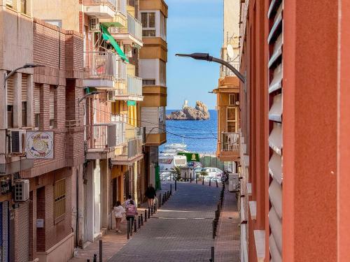 a street between buildings with a view of the ocean at PLAYA LEVANTE céntrico y con Parking By Aloha Palma in Águilas