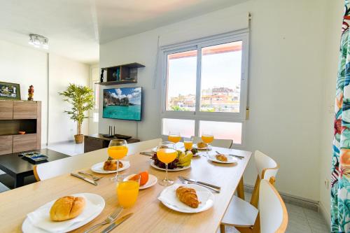 a dining room with a table with food and orange juice at PLAYA LEVANTE céntrico y con Parking By Aloha Palma in Águilas