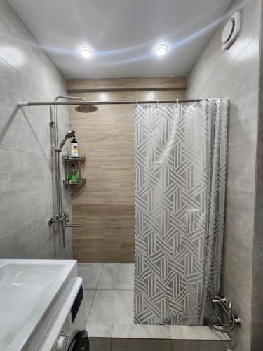 een badkamer met een douchegordijn en een wastafel bij Residence Apartment Osh Шикарные апартаменты в самом Элитном районе города Ош in Osh