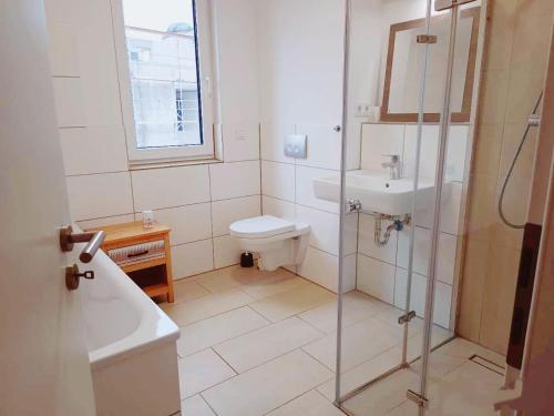 ein Badezimmer mit Dusche, Toilette und Waschbecken in der Unterkunft Neues 3ZimerHaus Düsseldorf Airport &Messe in Ratingen