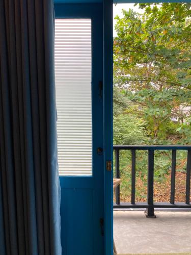 a blue door leading to a balcony with a window at Mahaon surf hotel in Weligama