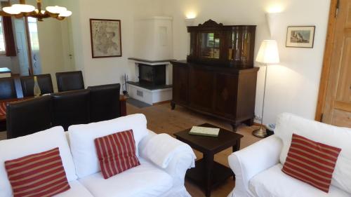 a living room with two white chairs and a piano at Parterre C WEST in Gingst