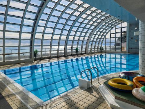 a large swimming pool with a glass ceiling at Hotel Cetus Royal in Higashiizu