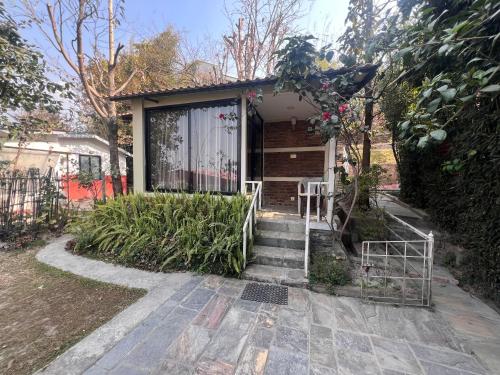 a house with stairs leading up to a door at Avocado Accommodations in Khadkagaon