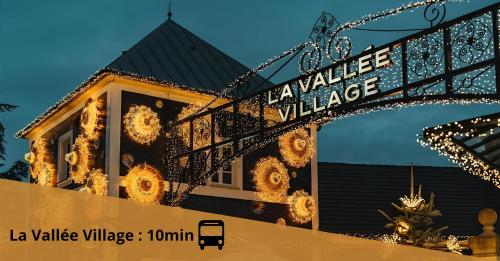 un bâtiment avec un panneau indiquant La Vallée Village dans l'établissement Cosy Appartement near Disneyland & Paris, à Coupvray