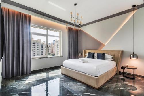 Un dormitorio con una cama y una ventana grande. en GuestReady - Palm Jumeirah delight, en Dubái