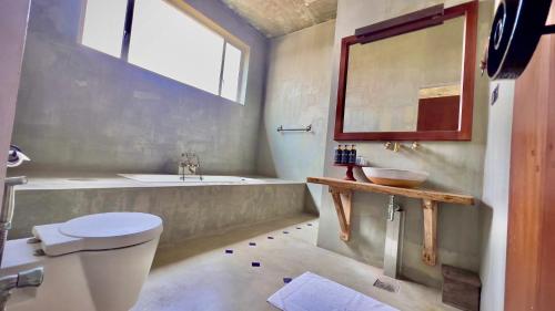 a bathroom with a toilet and a sink and a tub at Coza Ceylon in Mount Lavinia