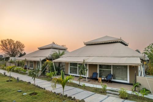 a house with a pitched roof and a patio at Sterling Tipeshwar in Pahāpal