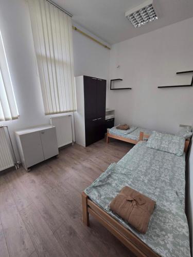 a bedroom with a large bed and a room with windows at Smestaj za radnike Stadion Lagator Loznica in Loznica