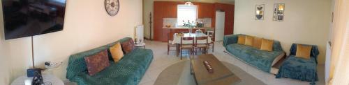 a living room with two green couches and a table at joanna's house in Alexandroupoli