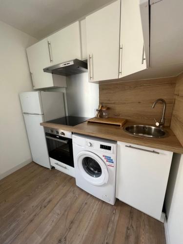 une cuisine avec une machine à laver et un évier dans l'établissement Appartement Farniente Grau d'Agde, au Grau-dʼAgde