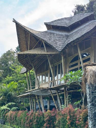 a large wooden building with a large roof at Sidemen Luxury Nyan Bali - Bamboo House in Selat