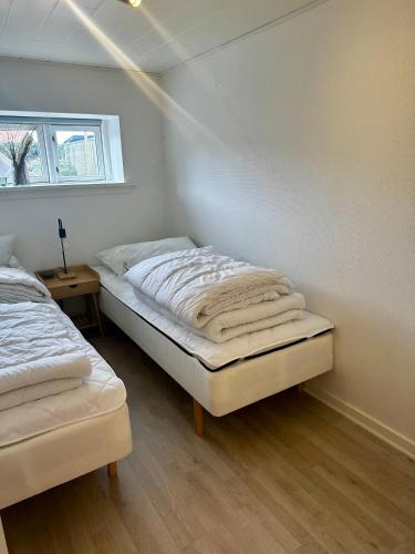 a bedroom with two beds and a window at Skøn lejlighed med egen terrasse og have tæt på centrum i Skagen in Skagen