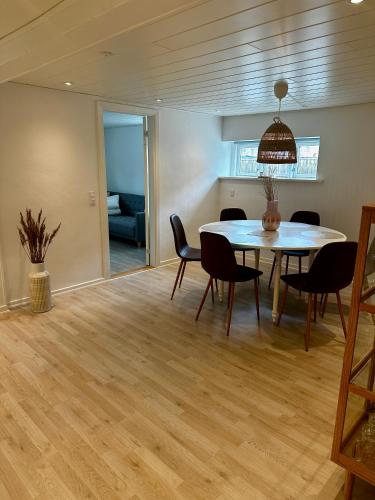 a dining room with a table and chairs at Skøn lejlighed med egen terrasse og have tæt på centrum i Skagen in Skagen