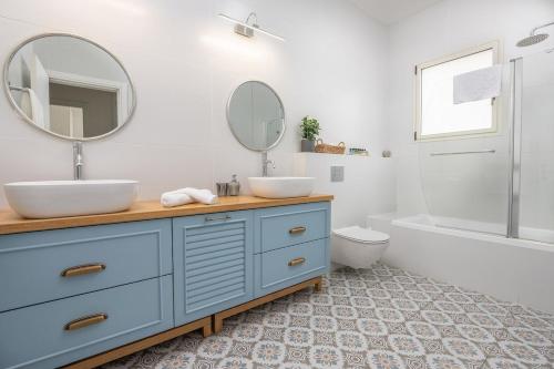 a bathroom with a blue dresser with two sinks and a mirror at לה וילא - וילה מדהימה עם בריכה פרטית וג'קוזי in Sderot