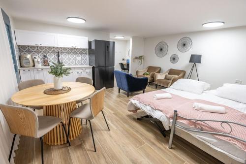 a bedroom with a bed and a table and a kitchen at לה וילא - וילה מדהימה עם בריכה פרטית וג'קוזי in Sderot