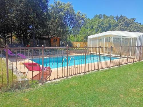 a fence around a swimming pool with a gazebo at Maison individuelle Grillon avec wifi in Grillon