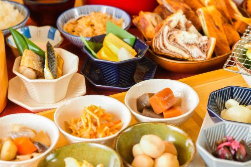 a table topped with bowls of different types of food at Sanco Inn Kyoto Hachijoguchi Shikinoyu in Kyoto