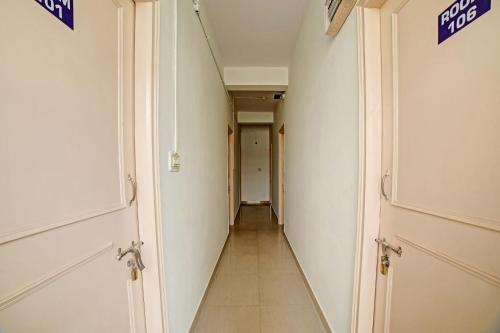 a hallway with two doors and a long corridor at Hotel O Fortuner Palace in Bengaluru