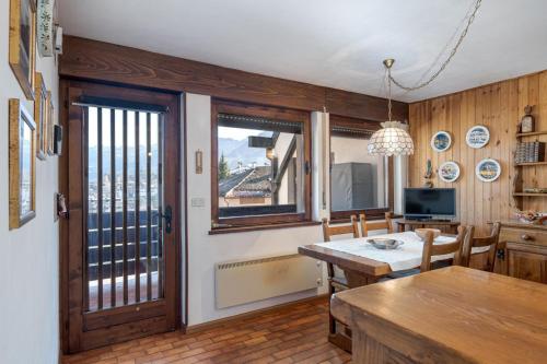 a kitchen with a table and a dining room at Appartamento Vittoria in Cavalese