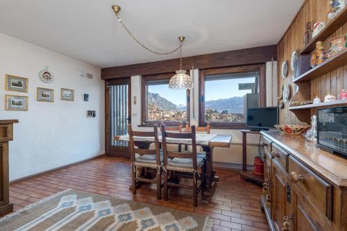 a kitchen with a table and a dining room with a view at Appartamento Vittoria in Cavalese