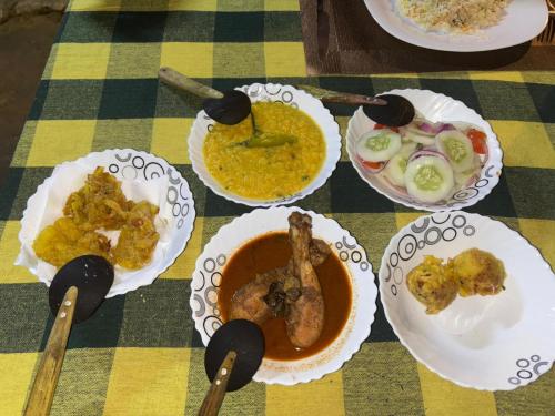 a table with plates of food and bowls of soup at lake paradise cabana in Tissamaharama