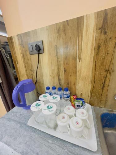 a tray with bottles of water on a counter at Paradise Inn by HBR in Dharmsala