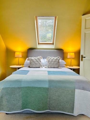 a bedroom with a large bed with two lamps at Seafront Cottage Amazing Seaview 3 Double Bedrooms in Westport