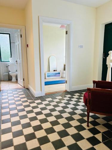 a bathroom with a checkered floor and a mirror at Seafront Cottage Amazing Seaview 3 Double Bedrooms in Westport