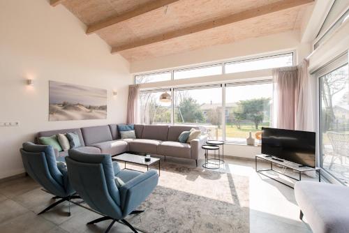 a living room with a couch and a tv at Klaver Vier (8p) in Ballum