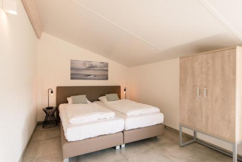 a bedroom with a bed and a cabinet at Klaver Vier (8p) in Ballum