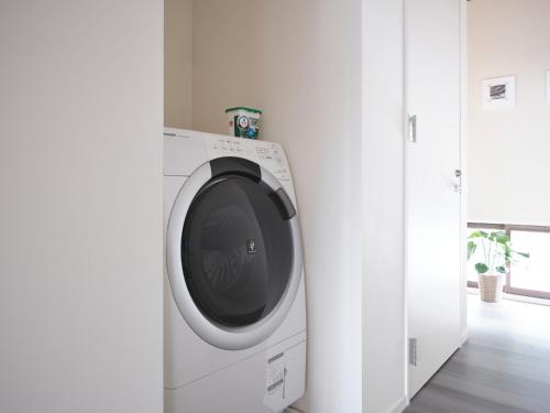 a washing machine in a room with a window at 佐渡古民家ステイ さどまり 泉の家 in Sado