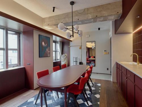 a kitchen with a dining room table and red chairs at illi Tex Aoyama in Tokyo